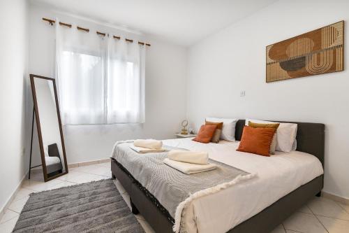 a bedroom with a large bed with orange pillows at Limnaria Gardens SUPERB VILLA by VICHY Holidays in Paphos