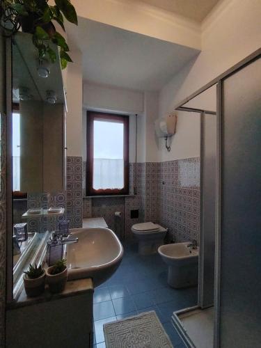 a bathroom with a sink and a tub and a toilet at Debby Appartamenti in Montepulciano