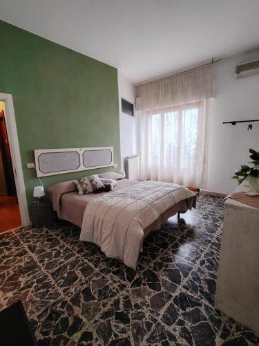 a bedroom with a large bed and a green wall at Debby Appartamenti in Montepulciano
