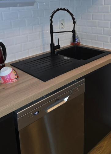- un comptoir de cuisine avec un évier noir et un comptoir dans l'établissement 3 Bedroom House - Disneyland Paris, à Magny-le-Hongre