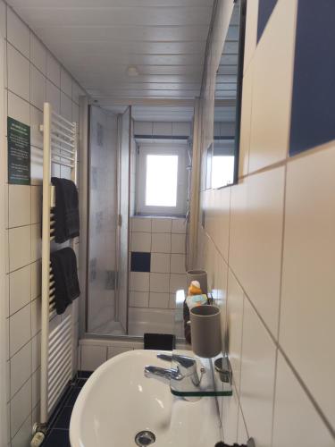 a bathroom with a white sink and a mirror at Hotel & Restaurant Zum Reussenstein in Böblingen