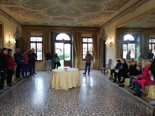 a group of people standing around a table in a room at Agriturismo Villa di Modolo - Cortile della Latteria in Belluno