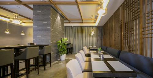 a restaurant with tables and chairs and a bar at Mehood Lestie International Hotel Chongqing Yuzhong Lianglukou Metro Station Branch - Free breakfast & Free afternoon tea & Free midnight snack in Chongqing