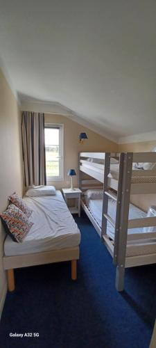 une chambre avec deux lits superposés et une fenêtre dans l'établissement La Petite Maison bleu, à Talmont-Saint-Hilaire