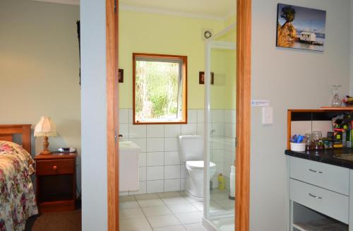 a bathroom with a shower and a toilet and a sink at Treetops B&B in Portobello