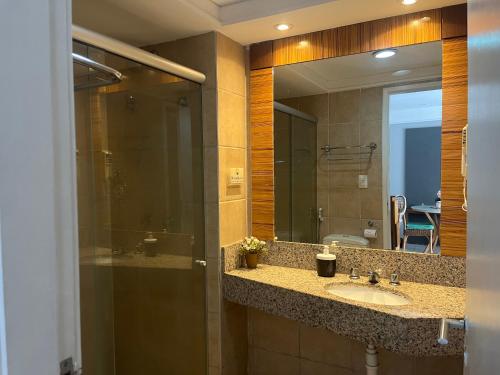 łazienka z umywalką i lustrem w obiekcie Flat Meireles Fortaleza w mieście Fortaleza