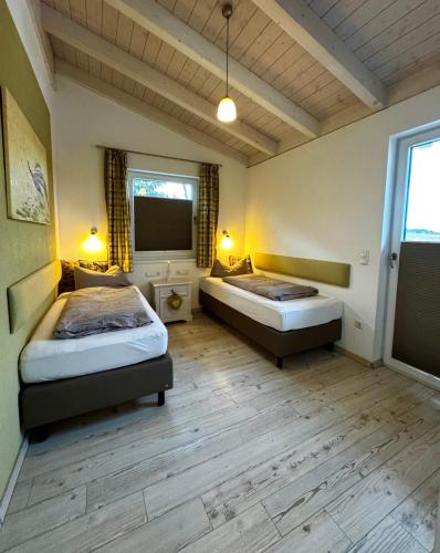 a bedroom with two beds and a flat screen tv at Ana's Landhaus auch für Monteure in Heretsried