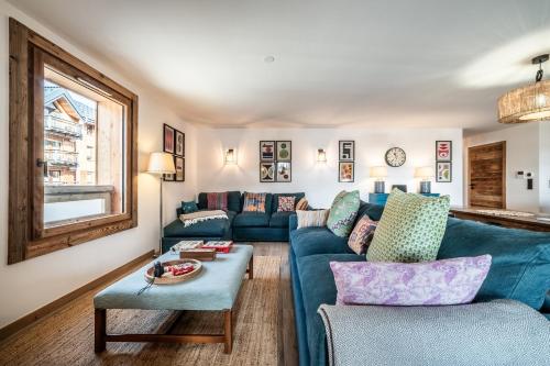 un salon avec un canapé bleu et une table dans l'établissement Apartment Heriz, Les Gets - by EMERALD STAY, aux Gets