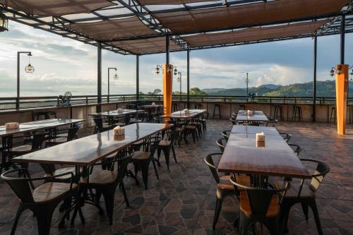 a restaurant with tables and chairs on a roof at KYRIAD M2 LAMPUNG in Lampung