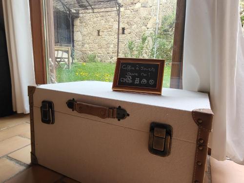 a briefcase with a sign sitting on top of it at Le Grenier à Blé in Satillieu