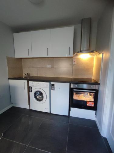 una cocina con lavadora y lavadora en Cozy Private Self-Contained Suite, en Oldbawn