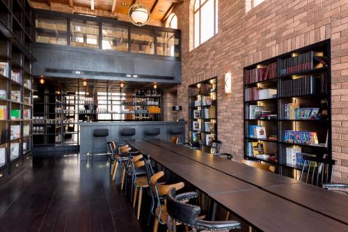 a long table in a library with chairs and bookshelves at Toscana Hotel La Casetta in Mu Si