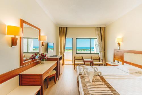 a hotel room with a bed and a mirror at Sural Hotel in Side