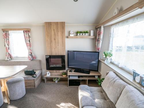 a living room with a couch and a tv at North Shore Skegness, 3 Bedroom 2 Bathroom Sleeps 8 in Skegness