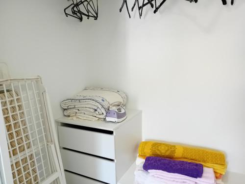 una habitación con un estante blanco con toallas. en apartamento Zarco, en Machico