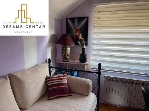 a living room with a couch and a window with blinds at Apartments Dreams Centar in Živinice