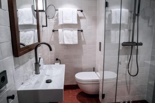 a bathroom with a toilet and a glass shower at Fågelbro Säteri in Värmdö