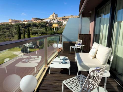 Un balcón con muebles blancos y vista a la ciudad. en Eolian Penthouse, en Milazzo