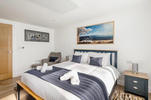 a bedroom with a large white bed with a blue blanket at Laurel Lodge - Stylish Two Bed & Free Parking in Box