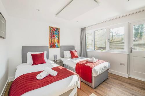 a bedroom with two beds and a window at Laurel Lodge - Stylish Two Bed & Free Parking in Box