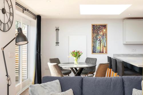 a living room with a blue couch and a table at Laurel Lodge - Stylish Two Bed & Free Parking in Box