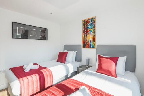 two white beds in a room with red pillows at Laurel Lodge - Stylish Two Bed & Free Parking in Box