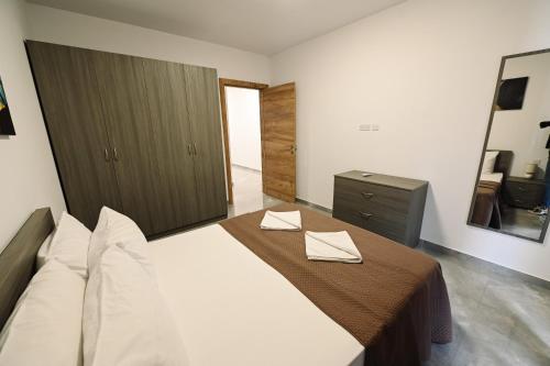 a bedroom with a bed with two napkins on it at Cerviola Luxury 3 bedroom Apartments in Il-Ħamrija