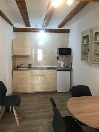 a kitchen with wooden cabinets and a table and chairs at Centrally located two bedroom apartment in Perelló