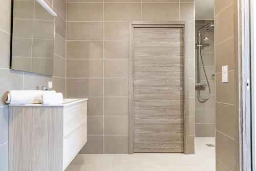 La salle de bains est pourvue d'une douche et d'une porte en bois. dans l'établissement A Chiusa, à Conca