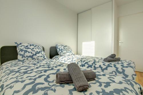 two beds with towels on them in a bedroom at Le George Sand parking privé in Blagnac