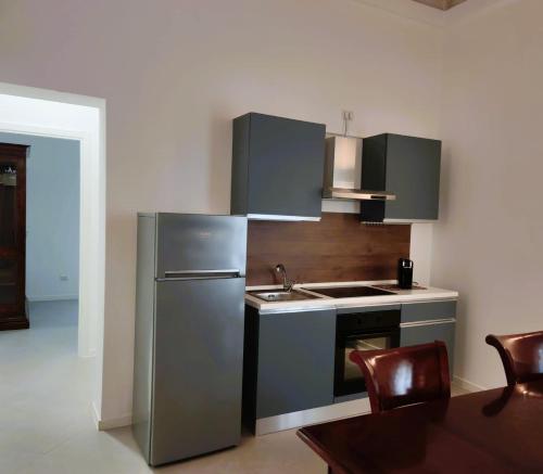 a kitchen with a stainless steel refrigerator and a sink at Palazzo Fragasso in Rutigliano