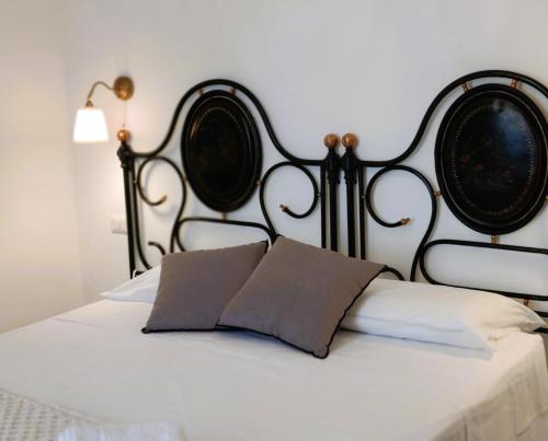 a bed with a black headboard and two pillows at Palazzo Fragasso in Rutigliano