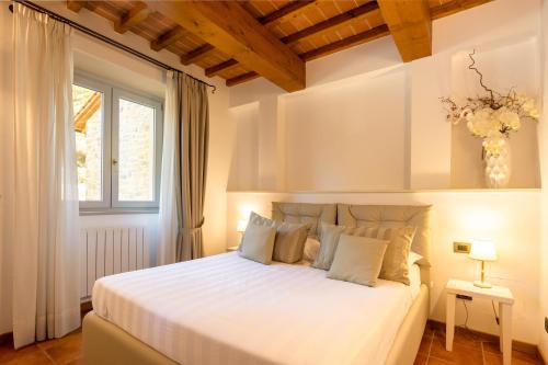 a bedroom with a white bed and a window at Villa Francesca in Poppi