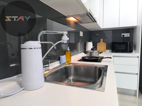 a kitchen counter with a sink and a stove at Almas Couple Urban Retreat Puteri Harbour BySTAY in Iskandar Puteri