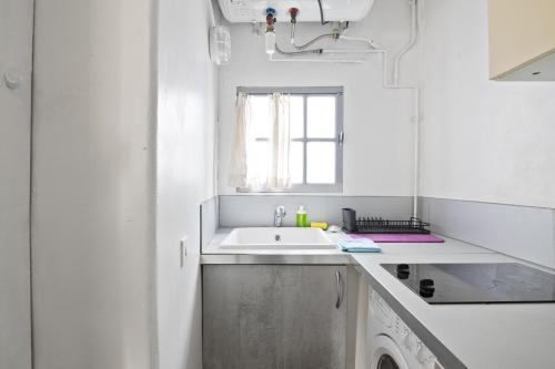 une cuisine blanche avec un évier et une machine à laver dans l'établissement Superb Apartment Quartier Les Marais Free Netflix, à Paris