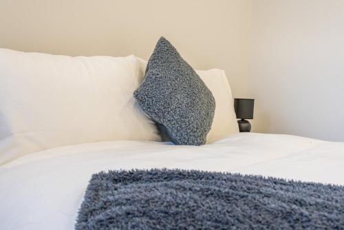 a white bed with two pillows on top of it at Royal Docks Cozy Studio Flat B in London