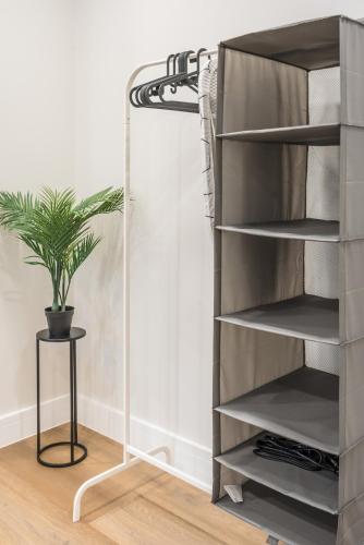 a shelf unit with a plant in a room at Royal Docks Cozy Studio Flat B in London