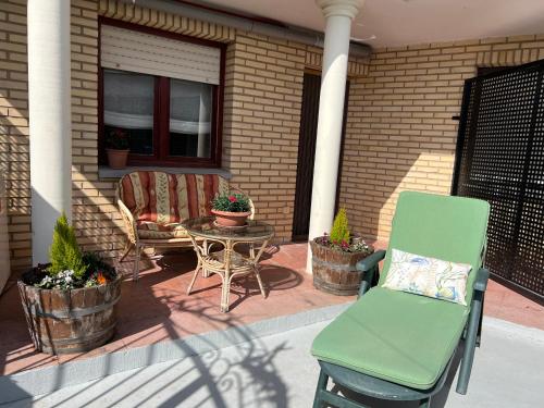 a patio with a chair and a table and some plants at Casa del Río in Hormilla
