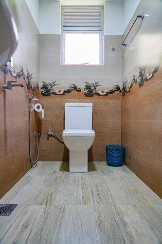 a bathroom with a white toilet and a window at Palm & Wild Hiriketiya in Dickwella