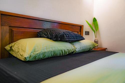 a bed with two pillows on top of it at Palm & Wild Hiriketiya in Dickwella