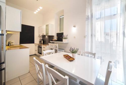 a kitchen and dining room with a white table and chairs at Golden Star Apartment - Spacious City Center Stay in Zagreb
