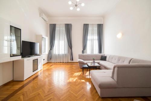 een woonkamer met een bank en een tv bij Golden Star in Zagreb