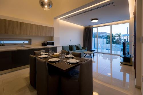 a dining room and kitchen with a table with wine glasses at Napa Hills Seaview Villas in Ayia Napa