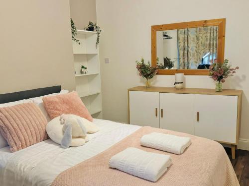 Un dormitorio con una cama con dos almohadas y un espejo. en Room 1 Shared House, en Litherland
