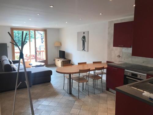 une cuisine et un salon avec une table et des chaises dans l'établissement Bel appartement 6 pers, terrasse plein sud, animaux admis, parking garage privé - FR-1-445-34, à Montgenèvre
