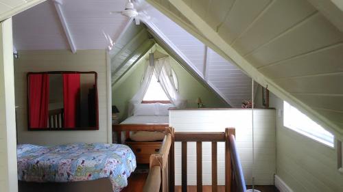a small attic room with a bed and a mirror at The Old Church Bed and Breakfast in Boonah