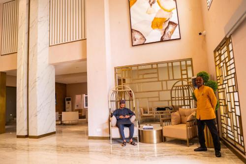 a man is sitting in a chair in a lobby at Porto Golf Hotels in Kano