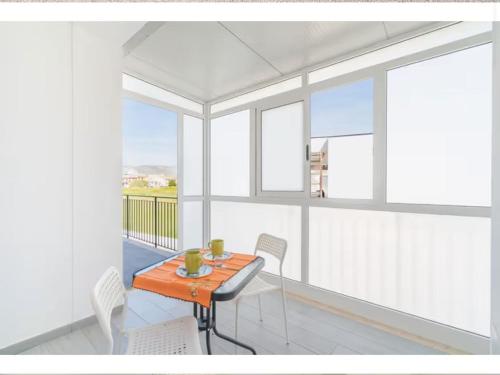 a dining room with a table and white chairs at Leverblu House in Marina dʼAvola