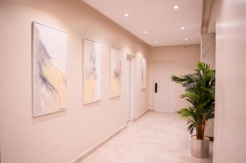 a hallway with paintings on the wall and a potted plant at Porto Golf Hotels in Kano