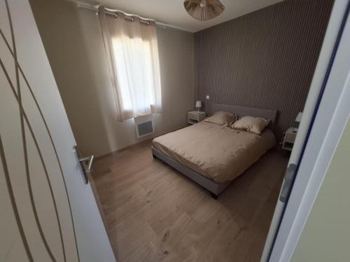 une petite chambre avec un lit et une fenêtre dans l'établissement Appartement 5B - Saintes, à Saintes